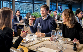 Tourists dining at a restaurant on the Eiffel Tower during a Paris day trip.