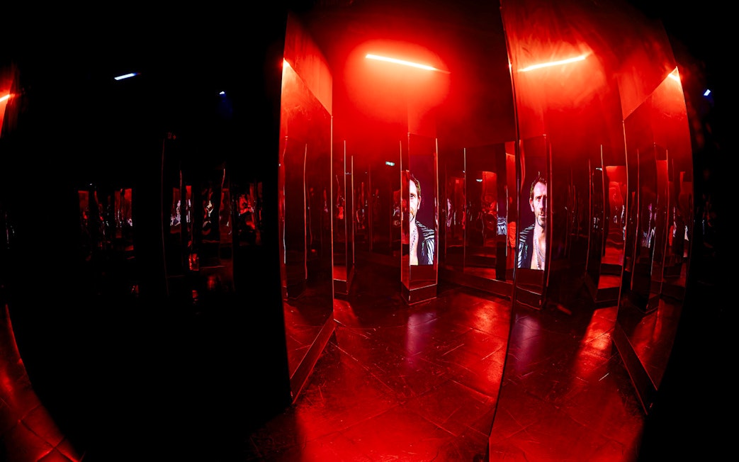 Mirrored maze with red lighting inside Amaze Amsterdam.