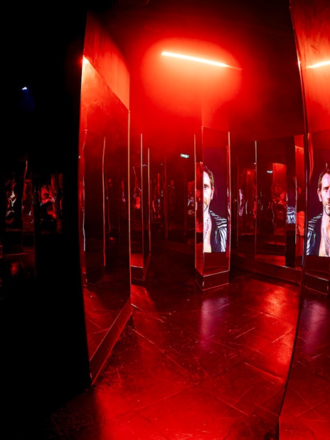 Mirrored maze with red lighting inside Amaze Amsterdam.