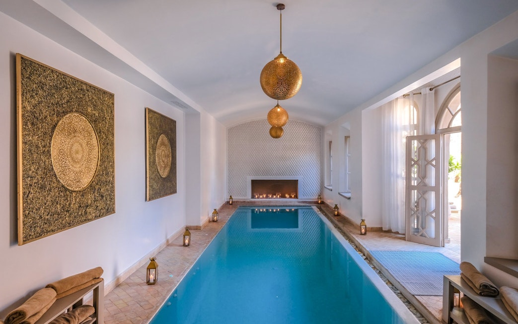 Luxurious indoor pool with lanterns and ornate decor at a steam hammam spa.