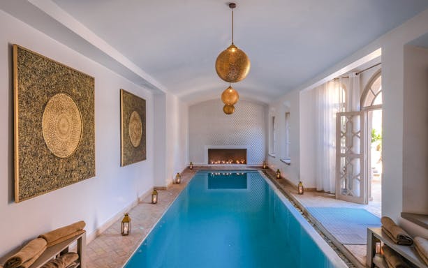 Luxurious indoor pool with lanterns and ornate decor at a steam hammam spa.