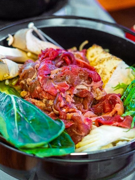 Traditional Yakatabune hot pot with vegetables and meat on a dinner cruise.