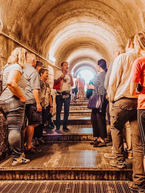Tour group with guide in Pompeii tunnel, Italy.