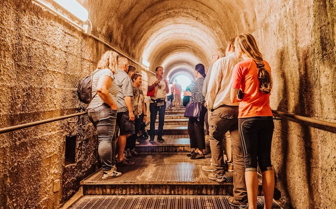 Tour group with guide in Pompeii tunnel, Italy.