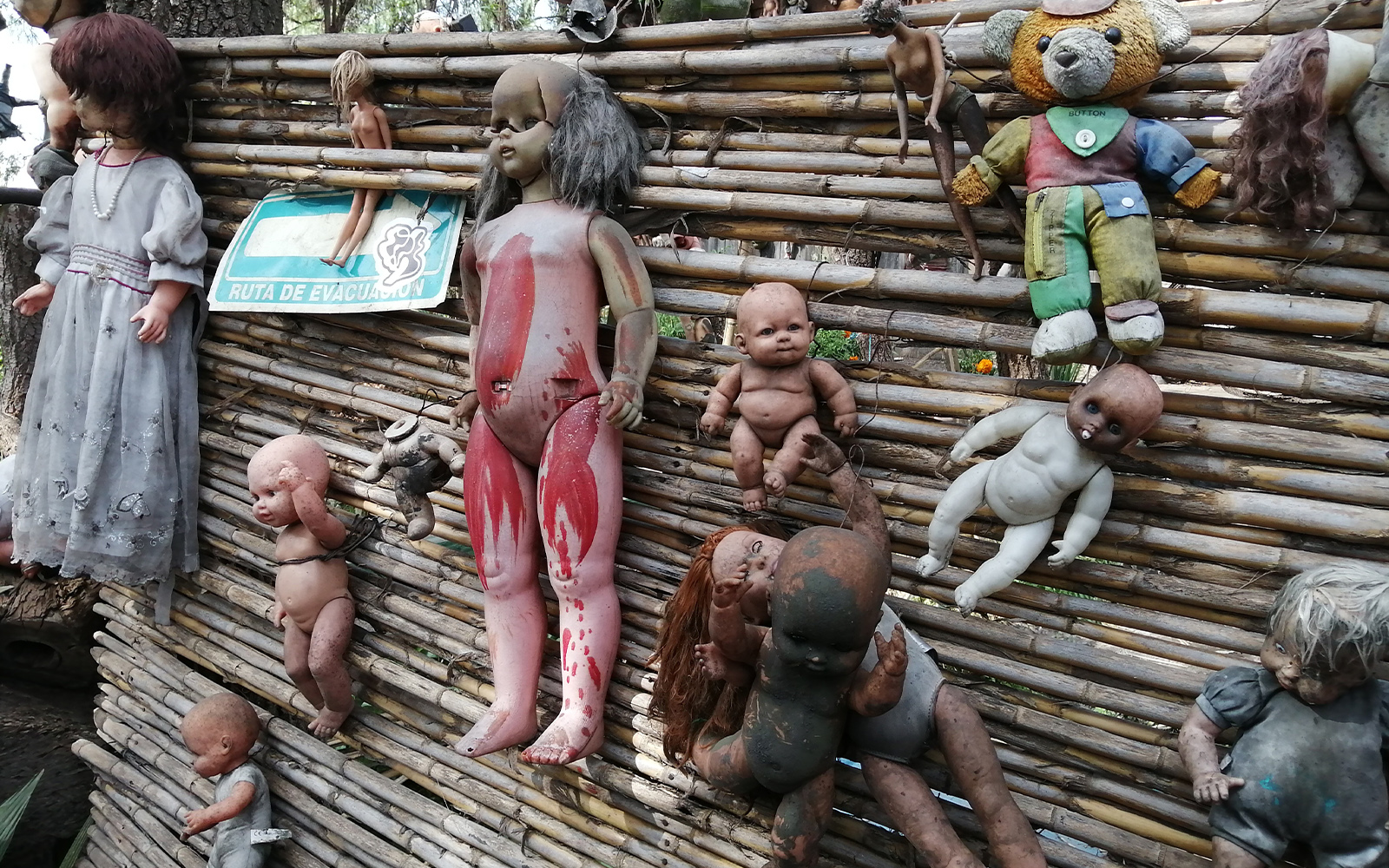 Xochimilco Island of Dolls canal with colorful boats and hanging dolls in Mexico City.