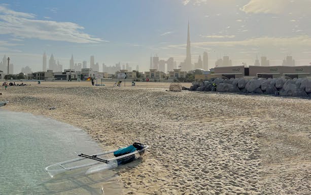 Clear kayak on Dubai beach with Burj Khalifa in the background.