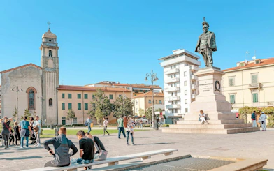 Piazza Garibaldi in Pisa with statue and people exploring the square.