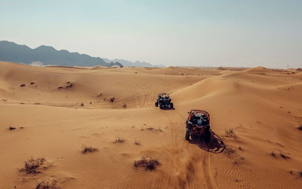 Dune buggies driving through desert landscape in Mleiha.