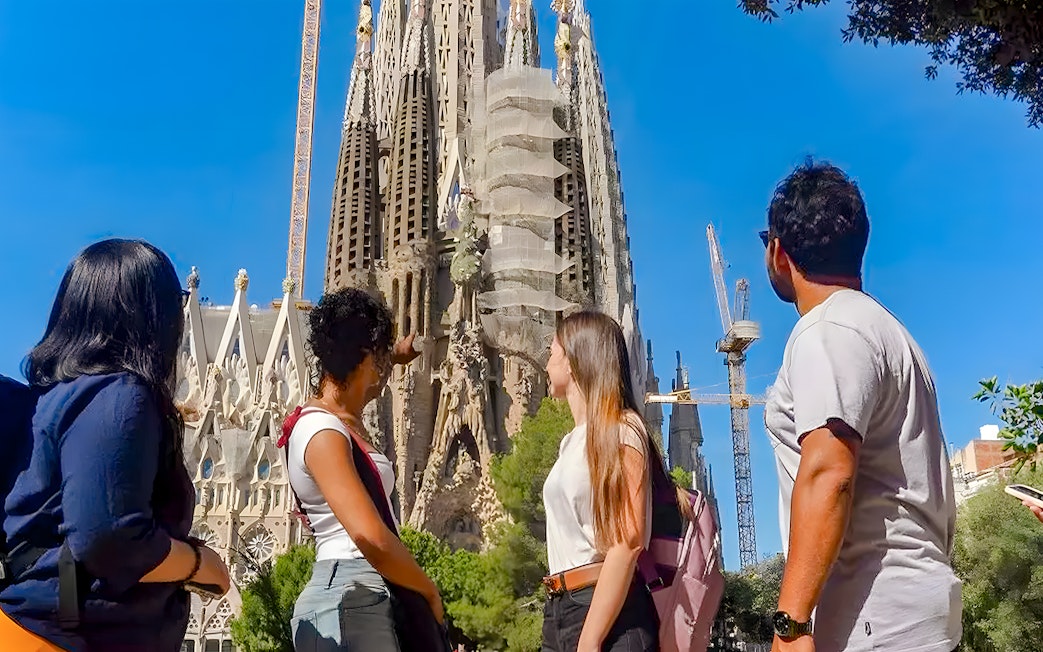 Tour group observing Sagrada Familia exterior in Barcelona.