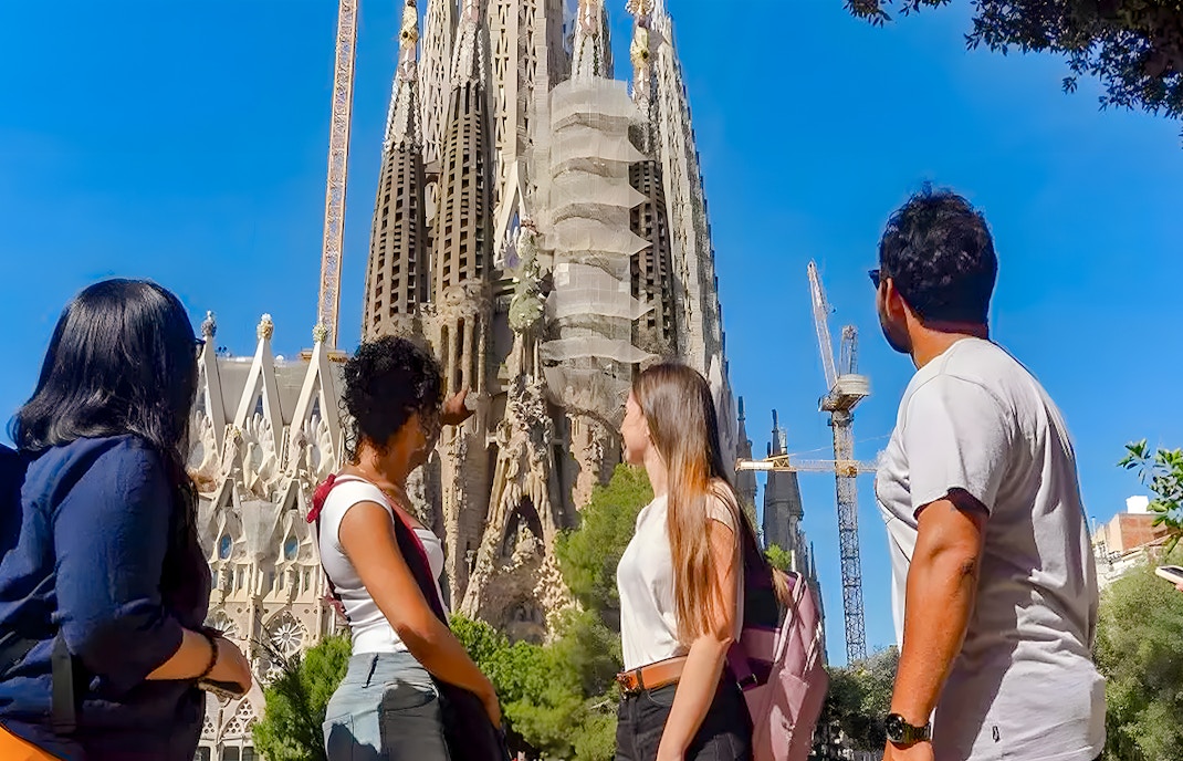 Tour group observing Sagrada Familia exterior in Barcelona.