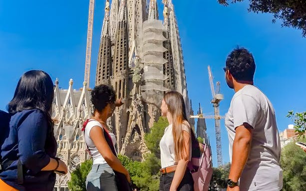 Tour group observing Sagrada Familia exterior in Barcelona.