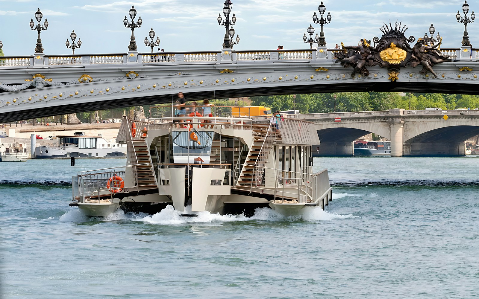 Seine River cruise boat passing under Pont Alexandre III in Paris.