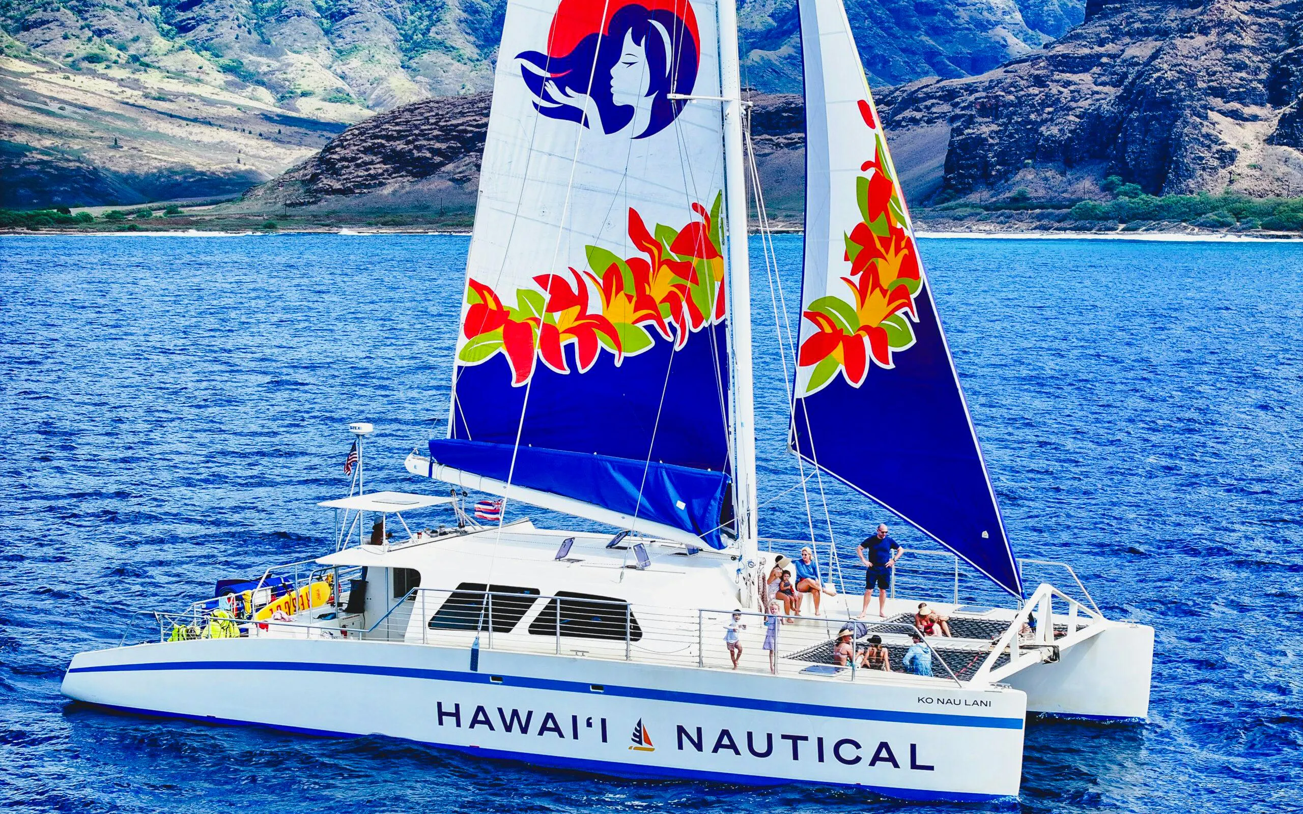 Sailing catamaran on West Oahu waters during whale watching tour.
