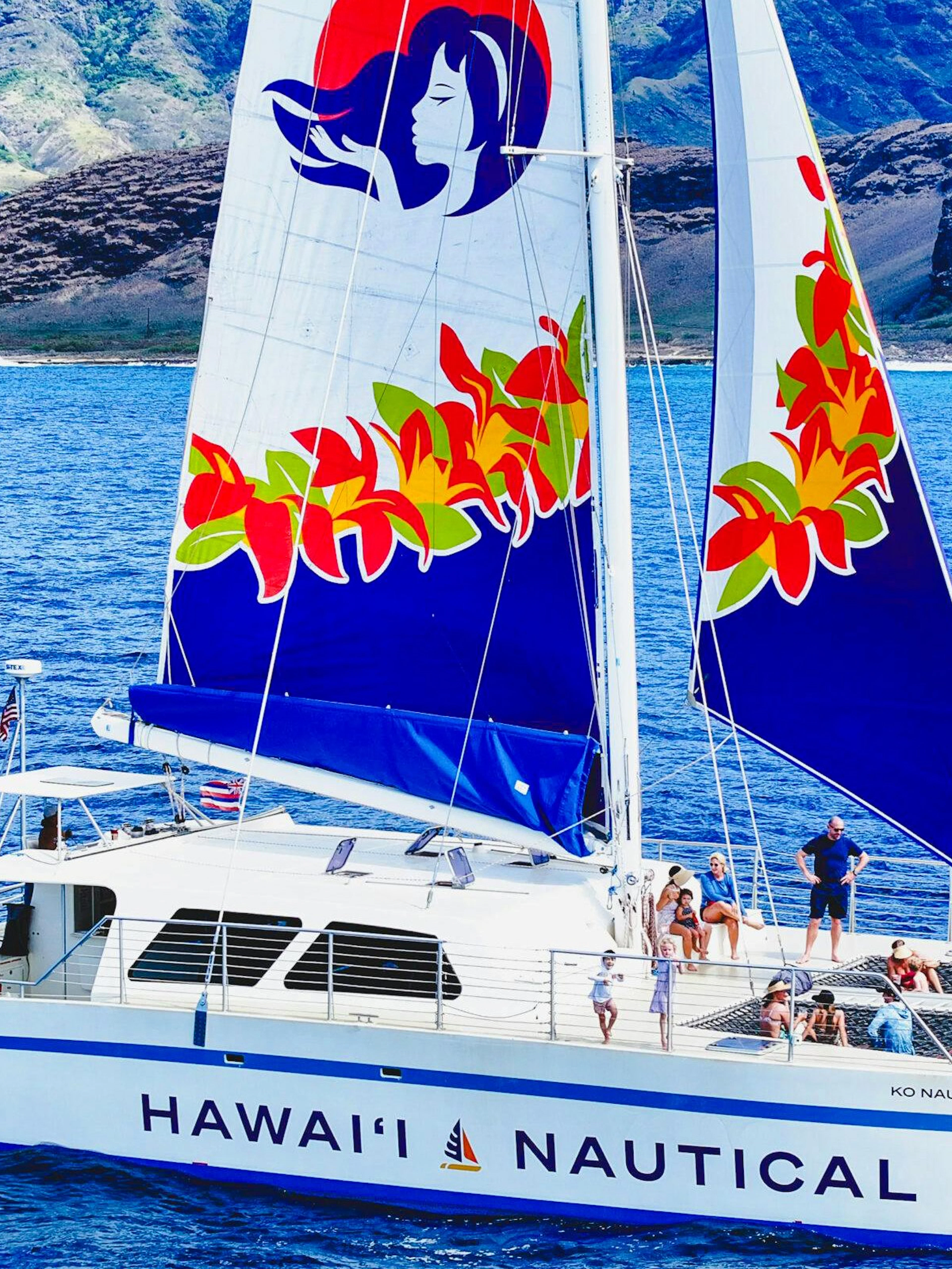 Sailing catamaran on West Oahu waters during whale watching tour.