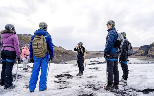 Guests hiking on Sólheimajökull glacier with guide in Iceland.