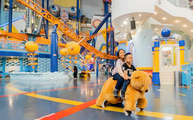Children riding a bear-shaped ride at Berjaya Times Square Theme Park, Kuala Lumpur.