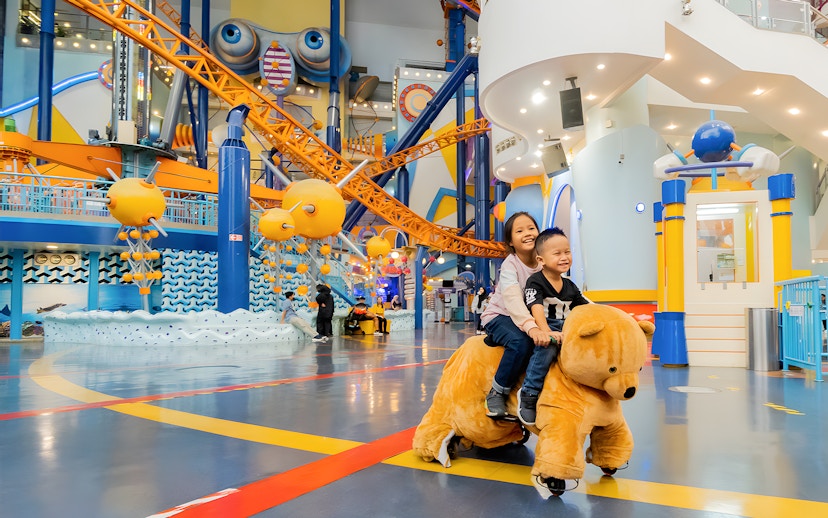 Children riding a bear-shaped ride at Berjaya Times Square Theme Park, Kuala Lumpur.