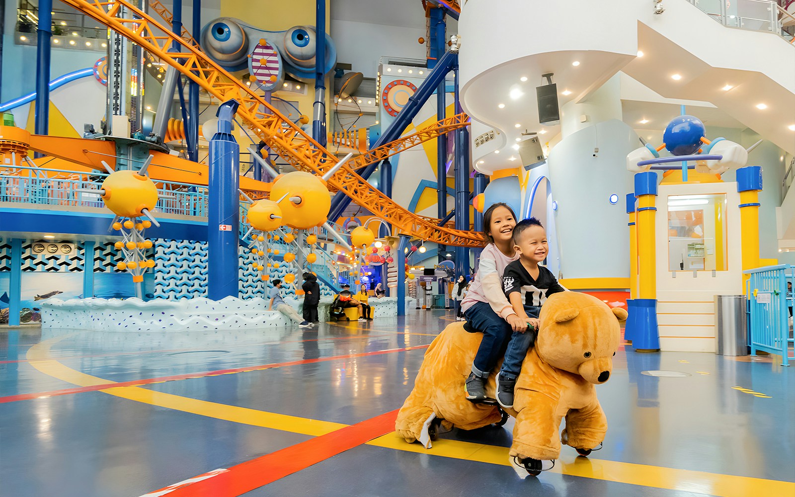 Children riding a bear-shaped ride at Berjaya Times Square Theme Park, Kuala Lumpur.