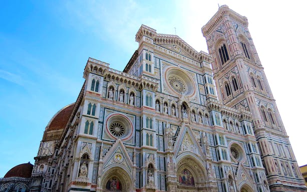 Florence Cathedral facade with bell tower, featuring intricate Gothic architecture.