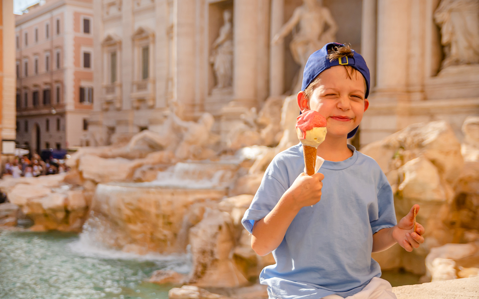 Boy enjoying gelato at Trevi Fountain, Rome.