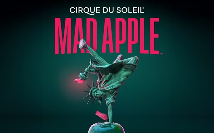 Statue of Liberty performing a handstand on an apple, promoting Cirque du Soleil's Mad Apple show.