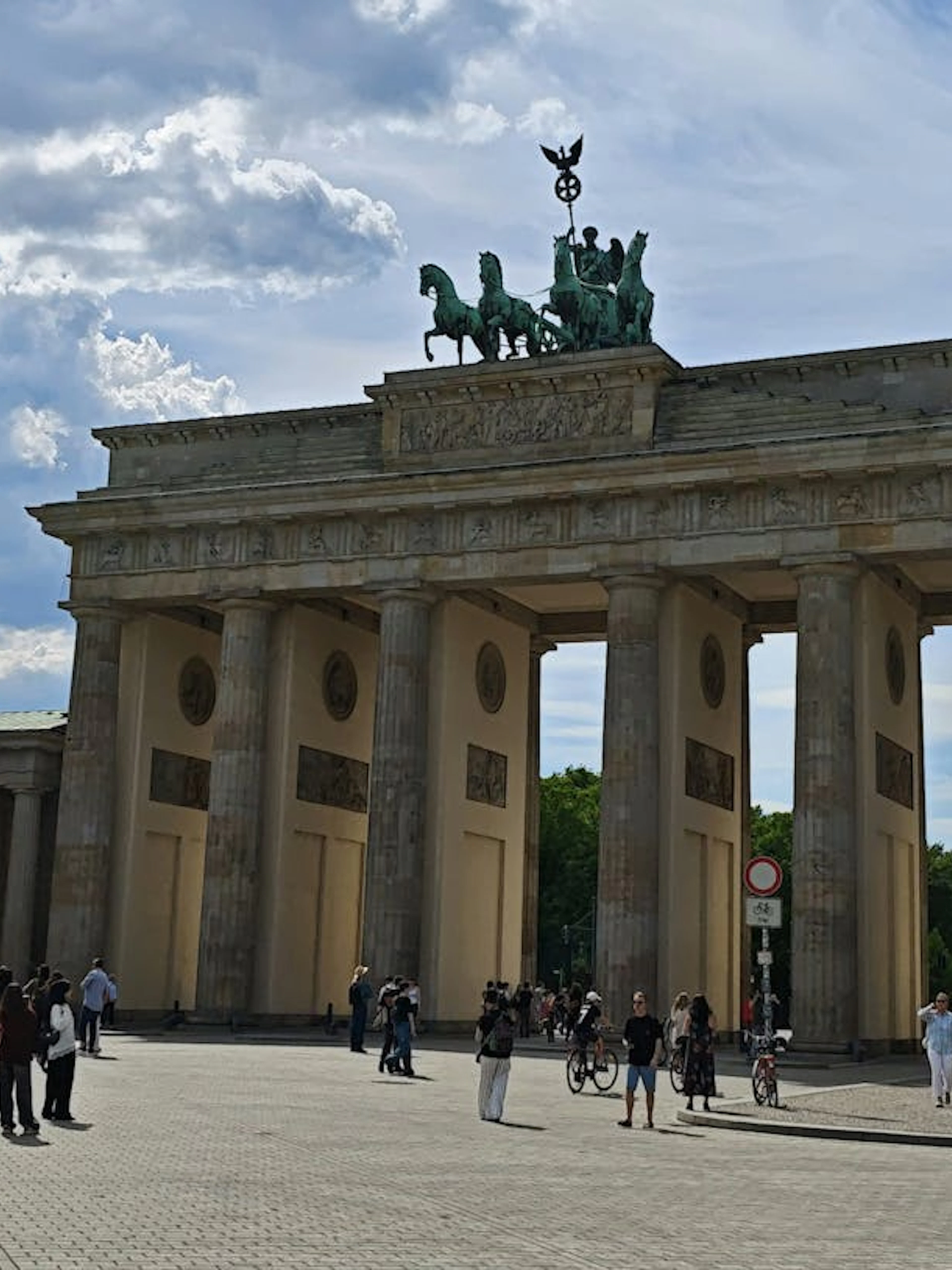 Brandenburg Gate in Berlin with tourists exploring the area.