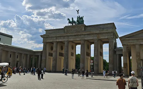 Brandenburg Gate in Berlin with tourists exploring the area.