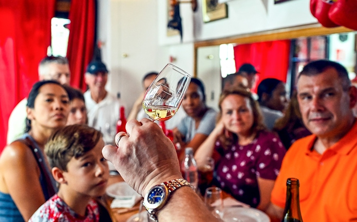 Tasting session at a Paris Saint Germain food tour with a group observing a wine glass.
