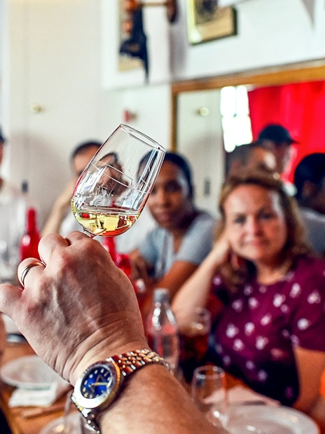 Tasting session at a Paris Saint Germain food tour with a group observing a wine glass.