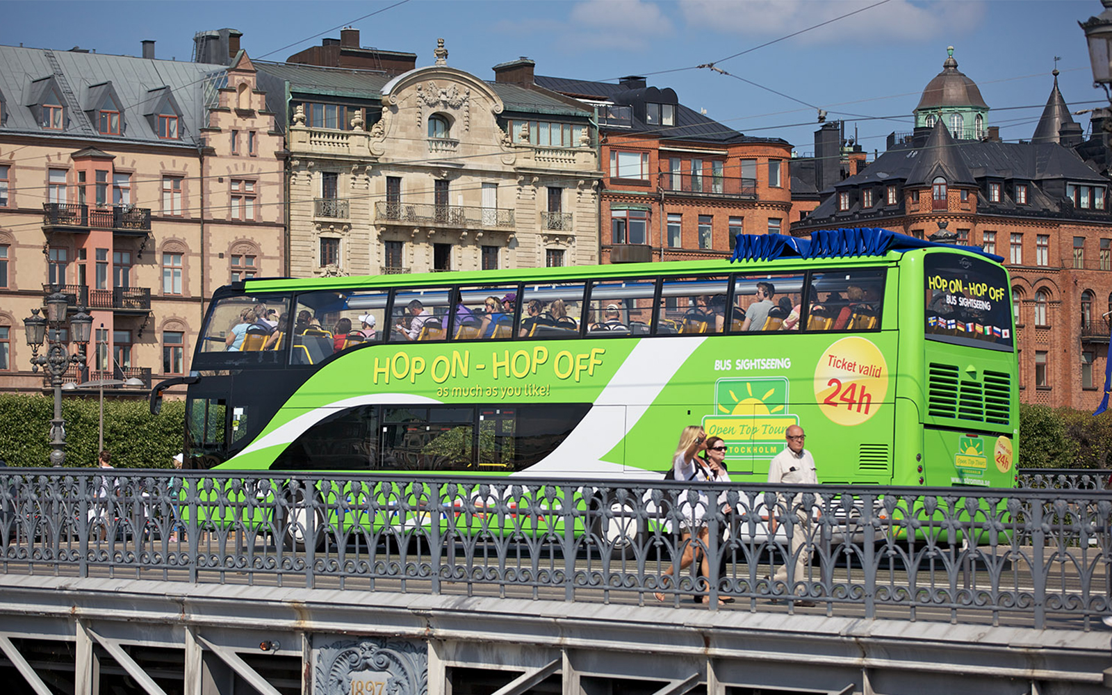 Hop-on hop-off bus in Stockholm with historic buildings in the background.