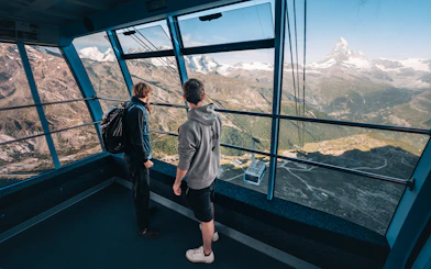 Tourists inside cable car with view of Matterhorn Glacier, Switzerland.