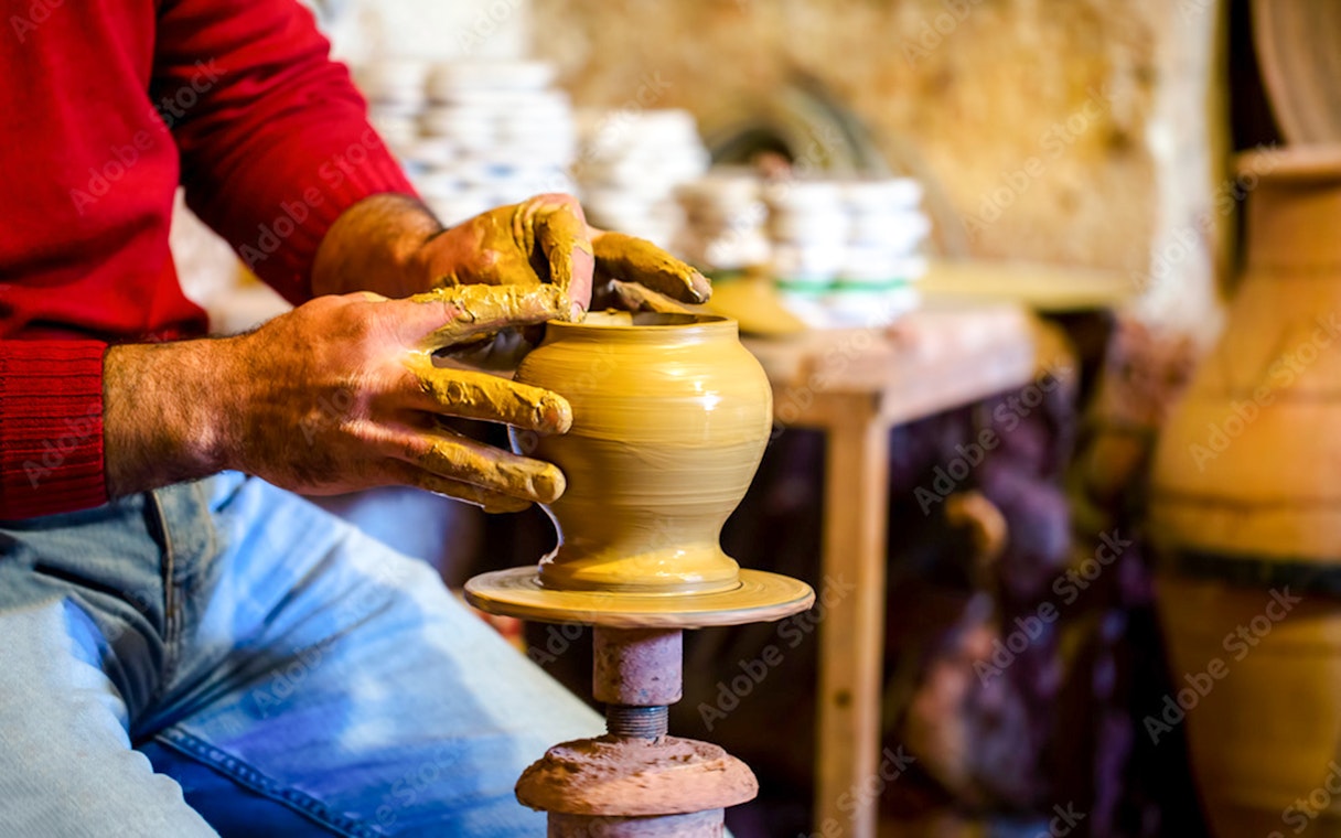Potter shaping clay on a wheel in Avanos workshop.