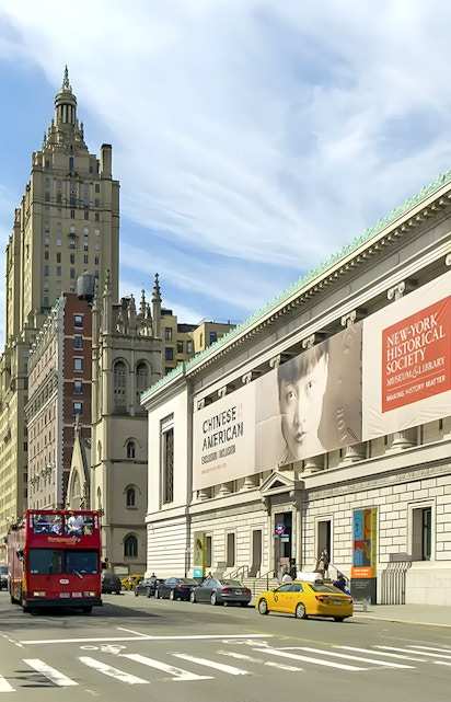 New York Historical Society building with exhibition banners and city street.
