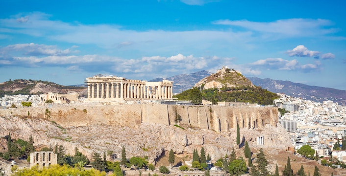 Athens Acropolis with Lycabettus Hill in the background, showcasing ancient ruins and cityscape.