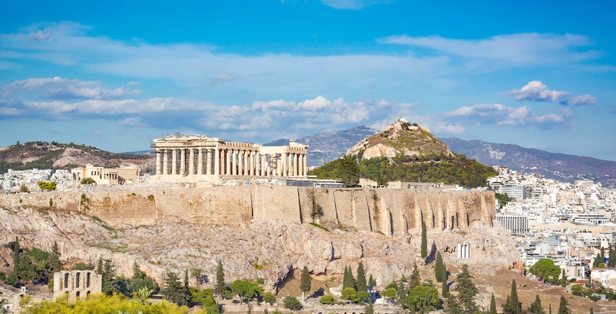 Athens Acropolis with Lycabettus Hill in the background, showcasing ancient ruins and cityscape.