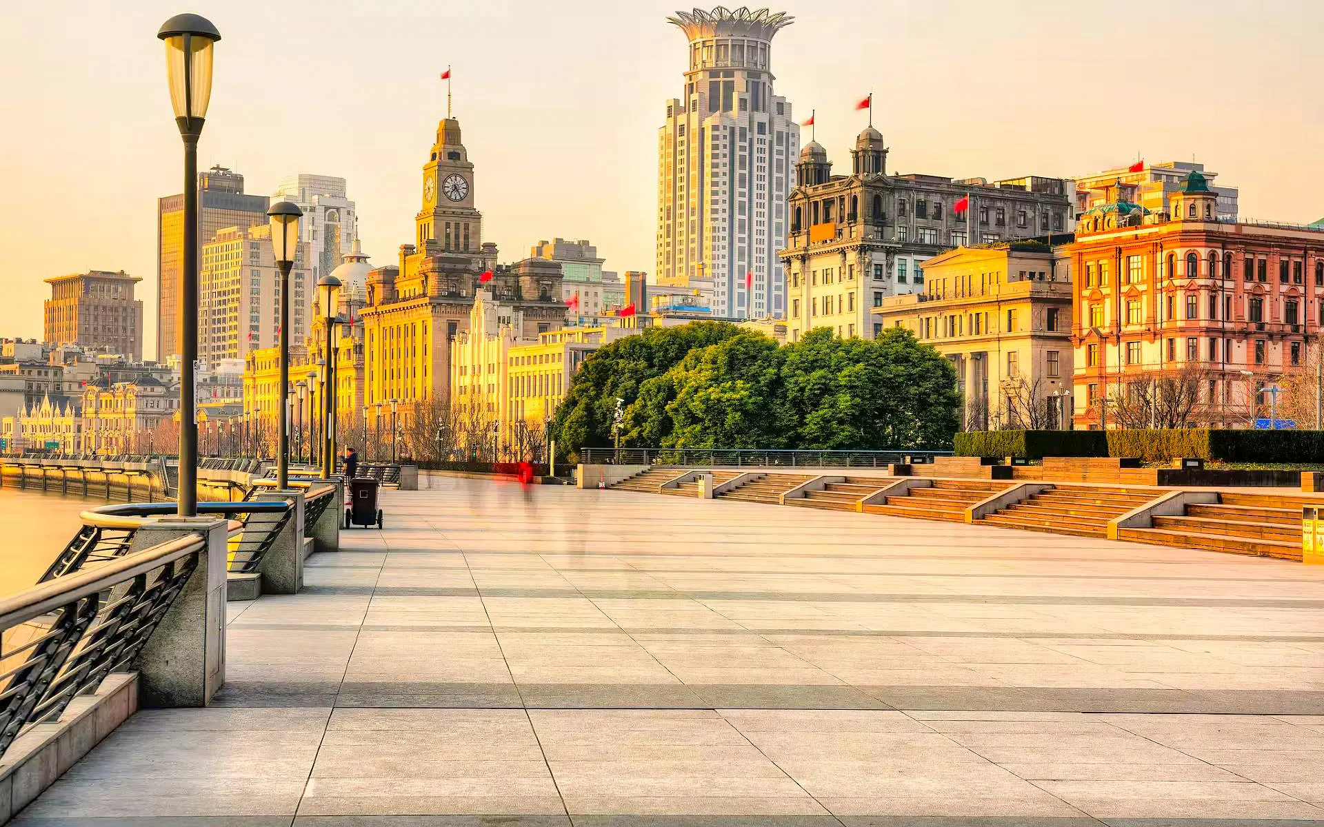Shanghai Bund waterfront promenade with historic buildings at sunset.