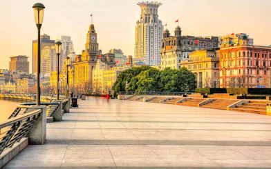 Shanghai Bund waterfront promenade with historic buildings at sunset.