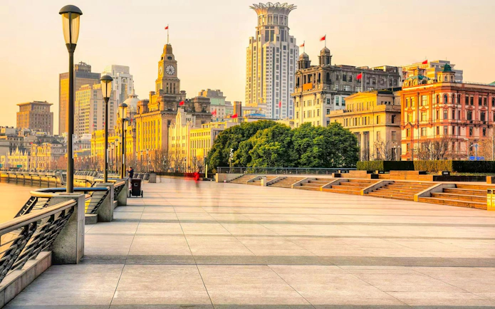 Shanghai Bund waterfront promenade with historic buildings at sunset.