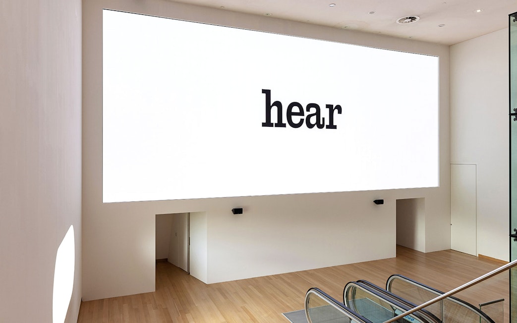 Installation view of IN SITU 1 Exhibit at Stedelijk Museum with "hear" text on wall.