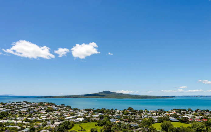 Rangitoto Island view from Auckland with blue sky and ocean.