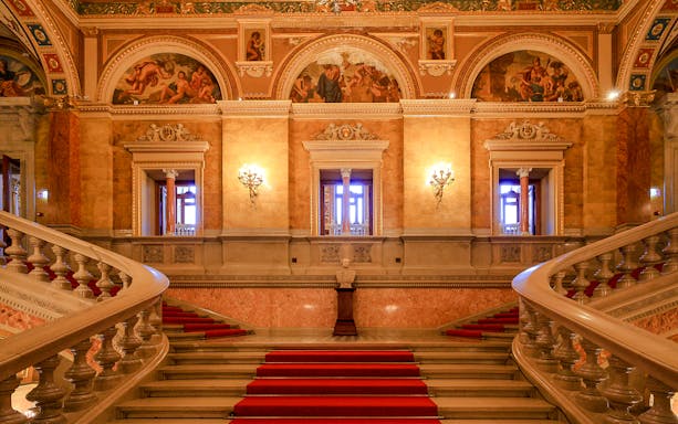 Grand staircase and ornate hallway inside the Hungarian State Opera, Budapest.