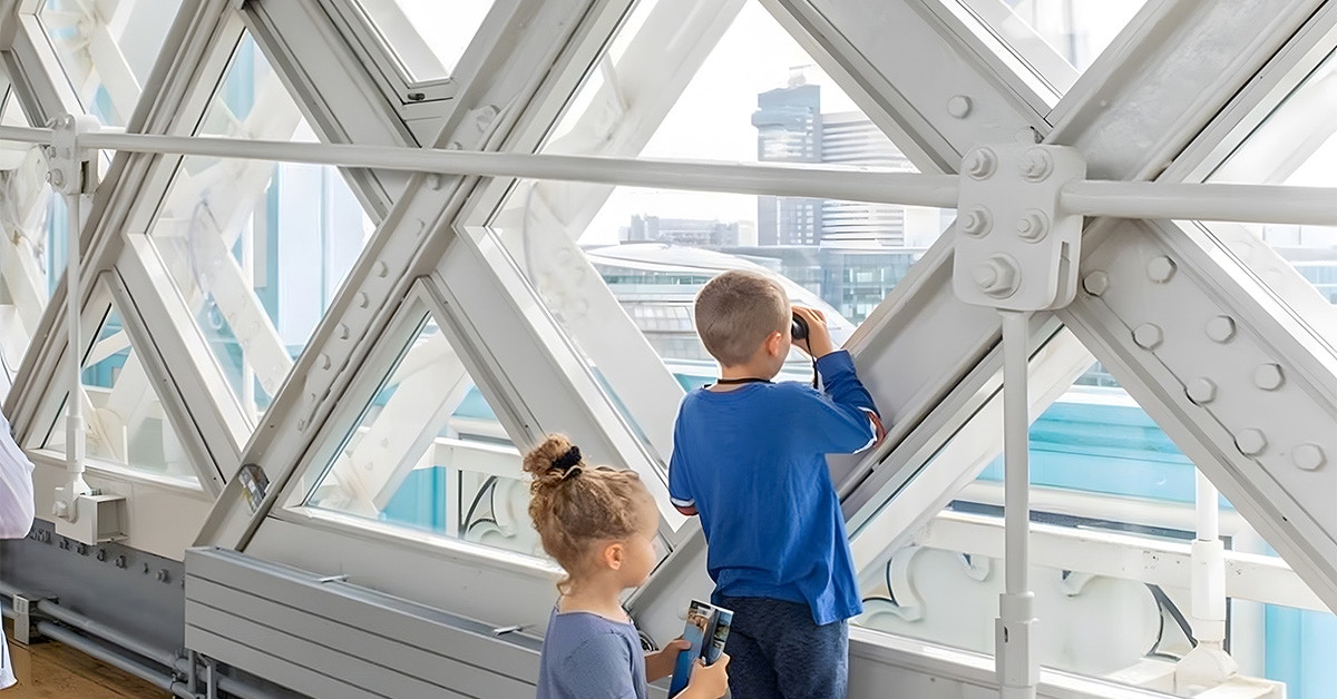 Guests observing London skyline from inside Tower Bridge.