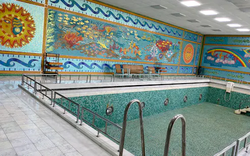 Indoor pool with mosaic walls in Ceaușescu’s Mansion, Bucharest, featuring vibrant aquatic designs.