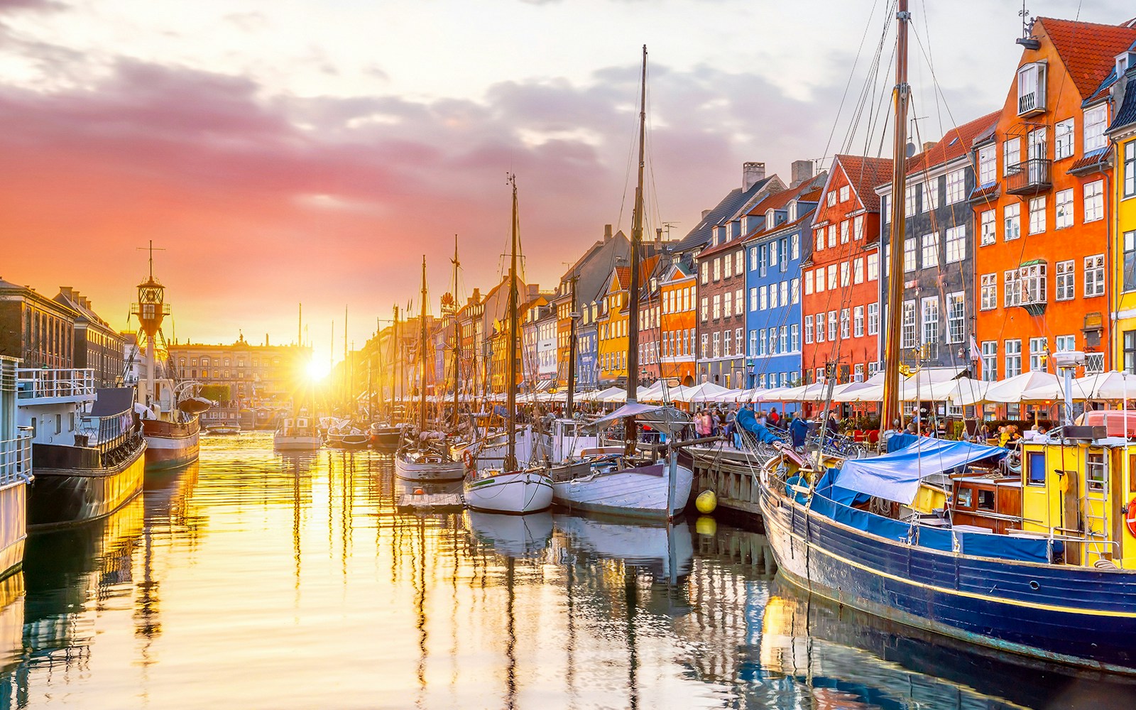 Nyhavn port in Copenhagen with colorful historic buildings and docked boats.