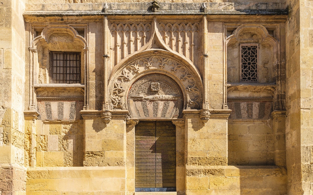 Original entrance of Mezquita, mosque-cathedral, Cordoba, featuring intricate stone carvings.