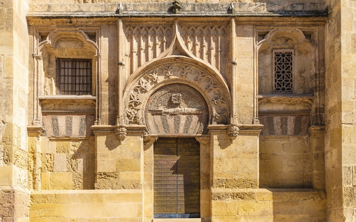 Original entrance of Mezquita, mosque-cathedral, Cordoba, featuring intricate stone carvings.