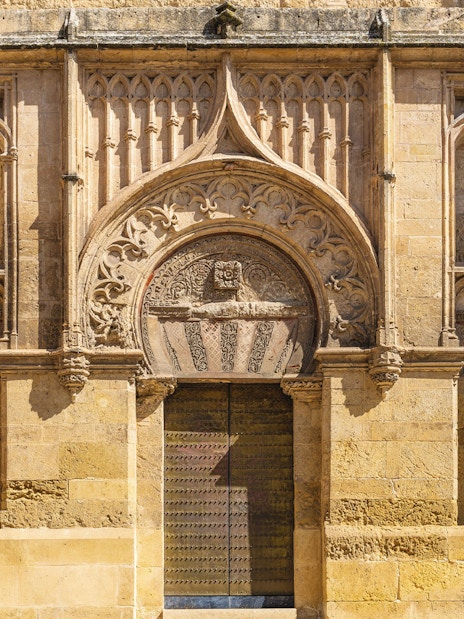 Original entrance of Mezquita, mosque-cathedral, Cordoba, featuring intricate stone carvings.