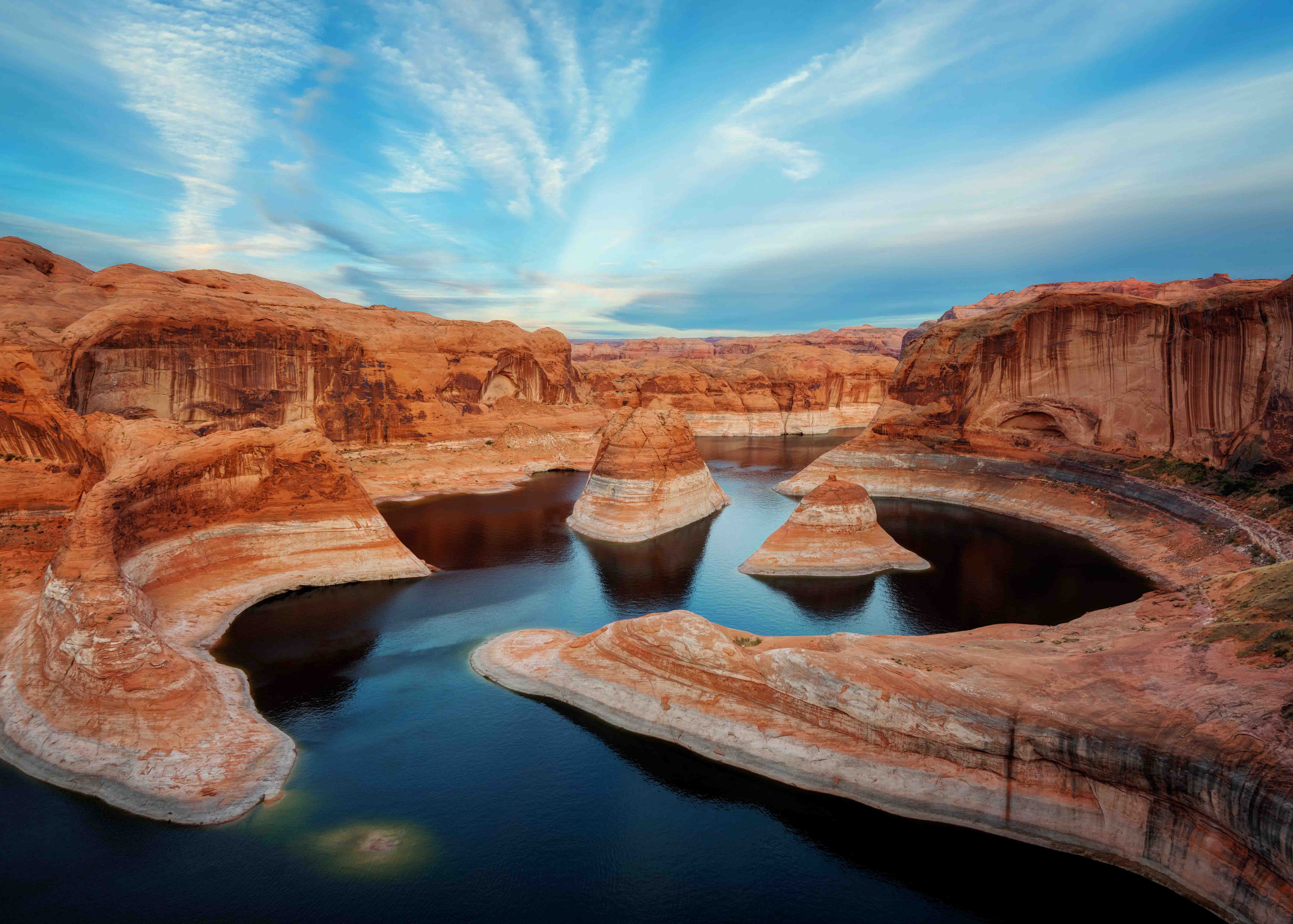 Rock formations and water at Lake Powell, Utah, under a blue sky.