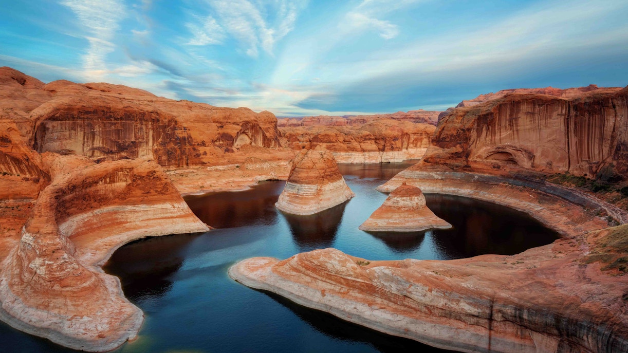Rock formations and water at Lake Powell, Utah, under a blue sky.