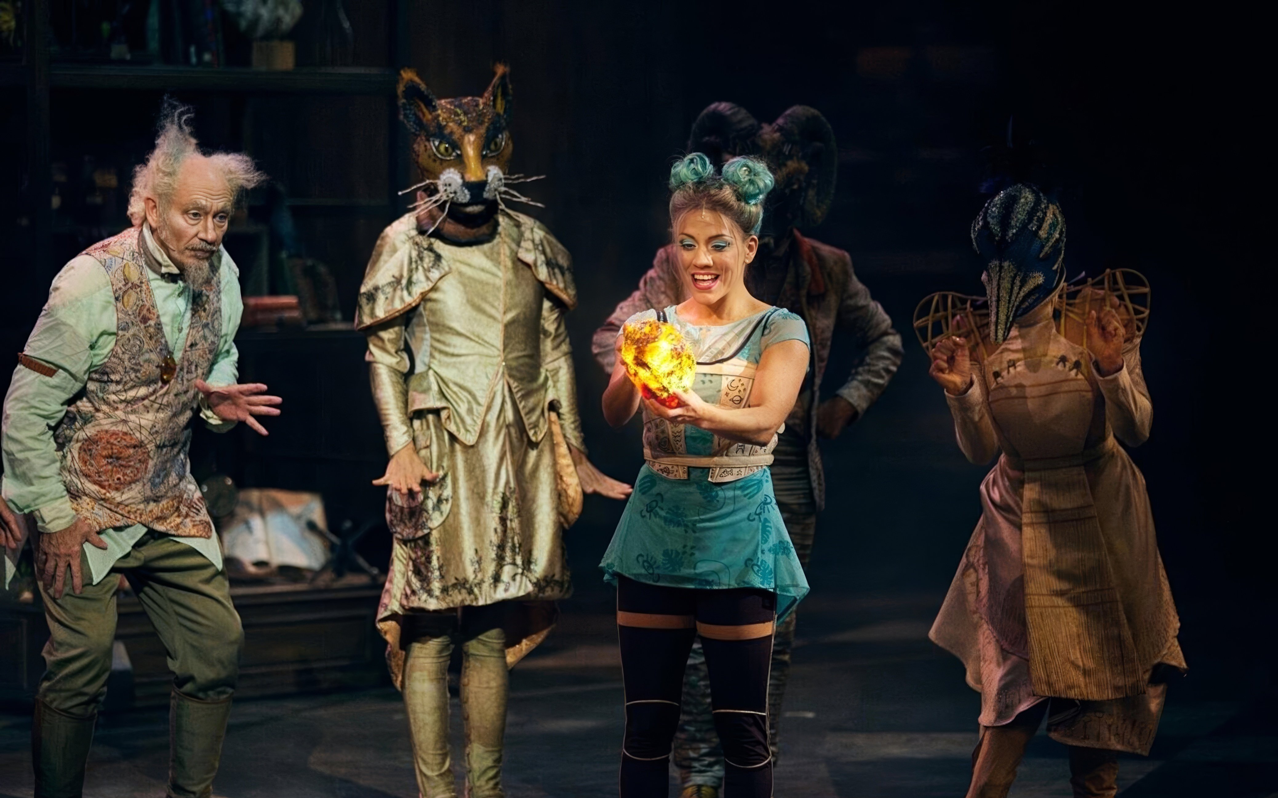 Performers in elaborate costumes at Cirque du Soleil Joya Show holding a glowing orb.